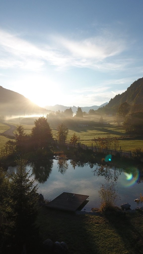 Badeteich in herbstlicher Landschaft.